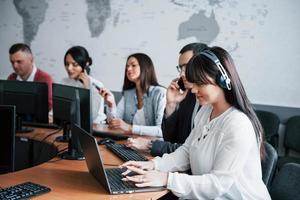 Searching information. Young people working in the call center. New deals is coming photo