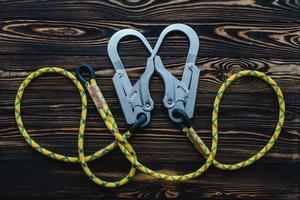 Connected ropes. Isolated photo of climbing equipment. Parts of carabiners lying on the wooden table