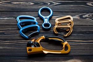 Looking good. Isolated photo of climbing equipment. Parts of carabiners lying on the wooden table