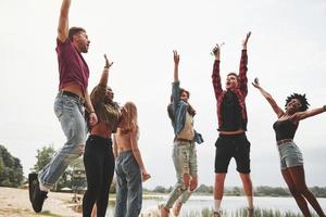 Finally it's friday evening. Group of people have picnic on the beach. Friends have fun at weekend time photo