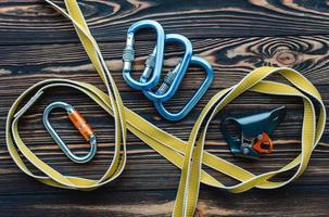 Yellow colored stripe. Isolated photo of climbing equipment. Parts of carabiners lying on the wooden table