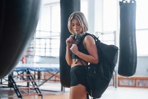 Attractive mature woman. Adult female with black bag and headphones in the training gym photo