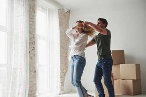 Dancing together. Young couple celebrating their removal to the new house photo