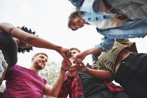 Giving bro fist. Multi ethnic group of people have party outdoors. View from down photo