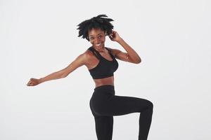 Dancing and having fun. Young beautiful afro american woman in the studio against white background photo