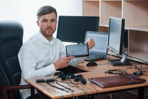 Young professional. Polygraph examiner works in the office with his lie detector's equipment photo