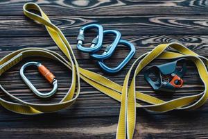 Made with quality material. Isolated photo of climbing equipment. Parts of carabiners lying on the wooden table