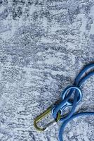 For testing human strength and stamina in mountains. Isolated photo of climbing equipment. Part of carabiner lying on the white and grey colored surface