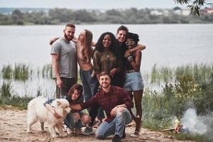 Group photo. People have picnic on the beach. Friends have fun at weekend time photo