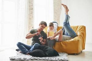 gran iluminación natural. pareja joven con un niño mirando juntos las fotos hechas por la cámara