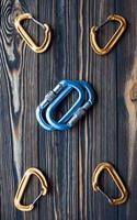 Many of objects. Isolated photo of climbing equipment. Parts of carabiners lying on the wooden table