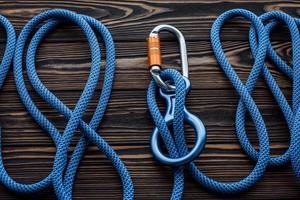 It will withstand your weight. Isolated photo of climbing equipment. Parts of carabiners lying on the wooden table