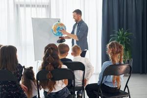 grupo de niños estudiantes en clase en la escuela con el maestro foto