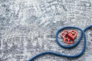 Active sports. Isolated photo of climbing equipment. Part of carabiner lying on the white and grey colored table