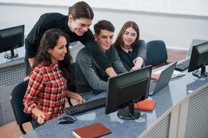 todo será genial. grupo de jóvenes con ropa informal trabajando en la oficina moderna foto