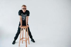 Positive man in casual clothes have fun in the studio against white wall photo