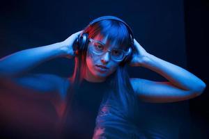 Art of cyberpunk. Studio shot in dark studio with neon light. Portrait of young girl photo