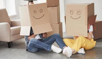 Smiles on boxes. Happy couple together in their new house. Conception of moving photo