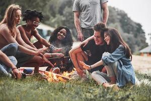 On vacation. Group of people have picnic on the beach. Friends have fun at weekend time photo