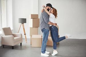 habitación grande. pareja feliz juntos en su nueva casa. concepción de movimiento foto