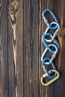 On the right side of the picture. Isolated photo of climbing equipment. Parts of carabiners lying on the wooden table