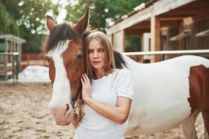escena rural. mujer feliz con su caballo en el rancho durante el día foto