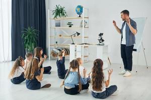 aprendizaje del lenguaje gestual. grupo de niños estudiantes en clase en la escuela con el maestro foto