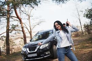 Morning streching. Couple have arrived to the forest on their brand new black car photo