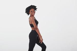 Turned side to the camera. Young beautiful afro american woman in the studio against white background photo