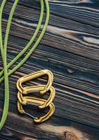 For dangerous travel. Isolated photo of climbing equipment. Parts of carabiners lying on the wooden table