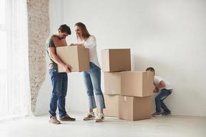 escondiéndose detrás de las cajas. la familia tiene mudanza a una nueva casa foto