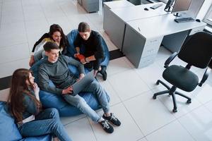 vista aérea. grupo de jóvenes con ropa informal trabajando en la oficina moderna foto