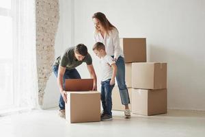 saquemos esto. la familia tiene mudanza a una nueva casa. desempacar cajas de mudanza foto