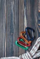 Going to the mountains this weekend. Isolated photo of climbing equipment. Part of carabiner lying on the wooden table