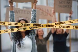 cinta que cubre los ojos de la niña. grupo de mujeres feministas tienen protesta por sus derechos al aire libre foto