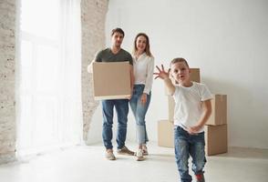 tratando de alcanzar la cámara. estado de ánimo juguetón del niño. la familia tiene mudanza a una nueva casa. desempacar cajas de mudanza foto