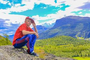 Cool colorful dressed man posing in front of Norway landscape. photo
