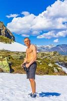 hombre en la nieve en verano en hydnefossen cascada hemsedal noruega. foto