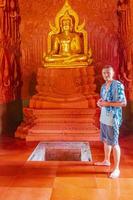 Traveler with golden buddha in red temple Wat Ratchathammaram Thailand. photo