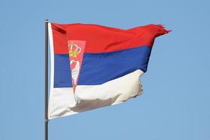 Serbian flag flying on flagpole photo