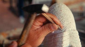 esculpir. un maestro que esculpe con talla de piedra. video