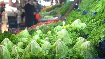 lockiges und grünes Gemüse. Frisches Gemüse aufgereiht auf der Gemüsetheke im Markt, Gesamtansicht des Marktes.