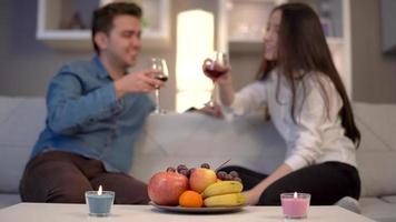 coppia che beve vino in chat. la coppia che beve vino sta chiacchierando allegramente. stanno ridendo e divertendosi. video