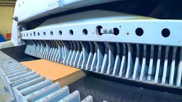 un ouvrier de production coupe une pile de papier d'impression sur un coupe-presse industriel dans la salle de production. travailler sur la machine avec vos mains video