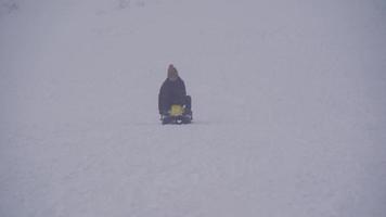 de jongen skiet in de sneeuw. de jongen schaatst met zijn skateboard in de besneeuwde lucht. video