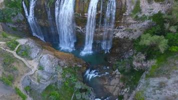 Waterfall Between Cliffs. Aerial view of a waterfall between rugged cliffs. video