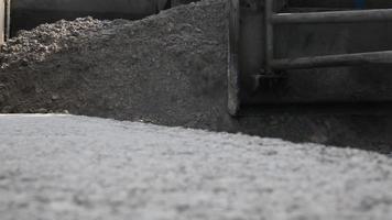 Straßenbau. Fahrbahnvorbereitung. Sand auf die Straße schütten. Arbeitsmaschine. Vorbereitung des Bodens für den Straßenbau. video