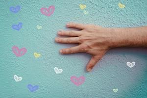 hand on the blue wall with hearts shapes, valentines's day photo