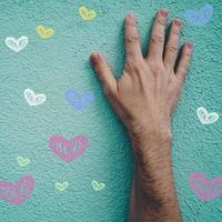 hand on the blue wall with hearts shapes, valentines's day