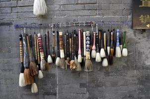 Assorted paintbrushes hanging on a wal. Street market in Pekin photo